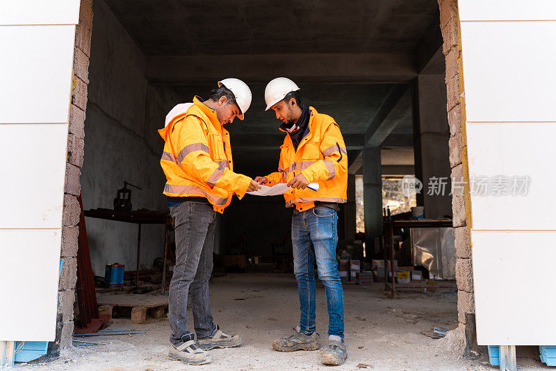 Two engineers having business meeting at construction site